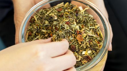 Teafüvet tartanak a kezükben. Egyikük kivesz a tálból egy keveset.